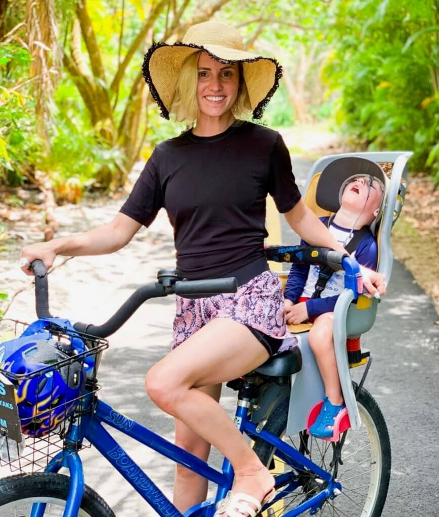mom rides bicycle with sleeping baby on sanibel