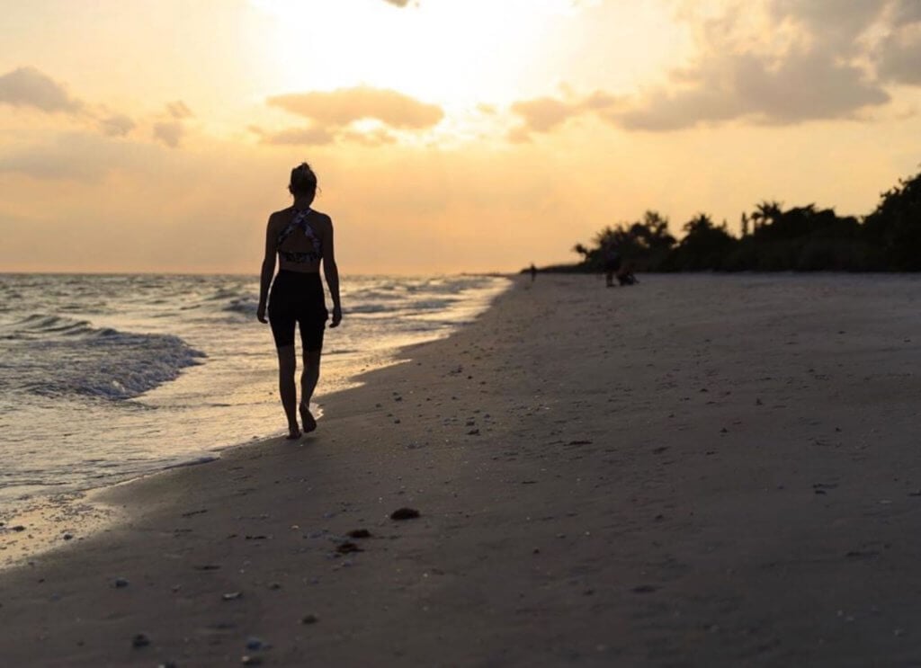 woman walks on sanibel beach